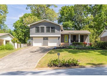 Charming two-story home with a well-manicured lawn and welcoming front entrance with a bright yellow door at 2991 Windfield Cir, Tucker, GA 30084