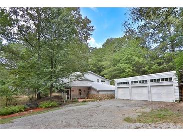 Charming home exterior featuring stone accents, three car garage, and mature trees at 20 Mahan Ne Ln, Rydal, GA 30171