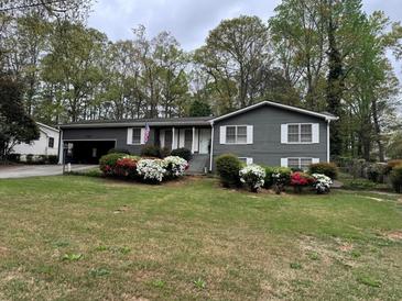 Charming home featuring a well-manicured lawn and colorful flowering bushes at 491 Scenic Hwy, Lawrenceville, GA 30046