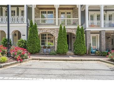 Charming townhouse exterior with brick facade, manicured landscaping, and inviting front porch at 963 Forrest St, Roswell, GA 30075