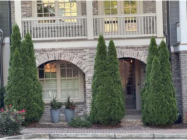 Charming brick townhome entrance with arched doorways and decorative landscaping at 963 Forrest St, Roswell, GA 30075