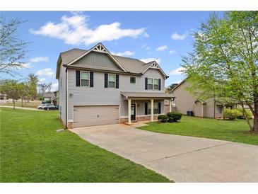 Charming two-story home featuring gray siding, black shutters, and a well-maintained front yard at 577 Joneus Dr, Mcdonough, GA 30252