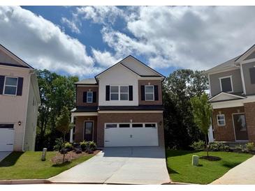 Inviting brick two-story home with a two-car garage and manicured front lawn at 1245 Elowen Dr, Austell, GA 30168