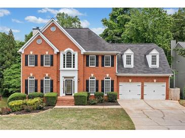 Charming brick two-story home with an attached two-car garage and lush front yard landscaping at 5344 Saint Martins Se Ct, Mableton, GA 30126