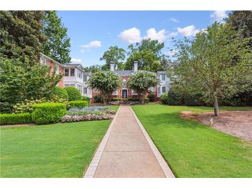 Charming brick apartment building with beautiful landscaping, lush lawn, and lovely walkway at 115 Peachtree Memorial Nw Dr # C1, Atlanta, GA 30309