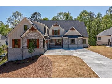 Beautiful home exterior featuring stone accents, gabled roof, and well-manicured landscaping at 71 Ramey Rd, Sugar Hill, GA 30518