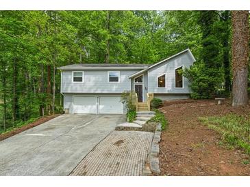Split level home with gray siding, front lawn, driveway and two car garage at 832 Wyntuck Nw Dr, Kennesaw, GA 30152