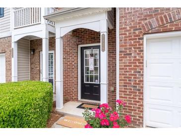 Inviting brick townhome entrance with a covered porch and well-manicured landscaping at 2826 Snapfinger Mnr, Decatur, GA 30035