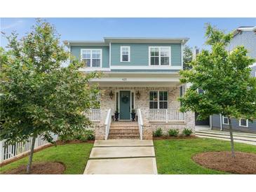 Charming two-story home featuring a brick facade, inviting front porch, and manicured lawn at 425 Harold Ne Ave, Atlanta, GA 30307