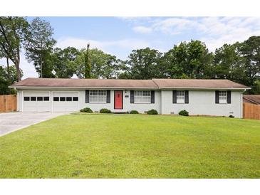 Charming ranch-style home featuring a well-manicured lawn, double garage, and a striking red front door at 2103 Blue Creek Ct, Conley, GA 30288