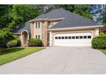 Charming home featuring a stone facade, well-manicured lawn, and a two-car garage with a grey shingled roof at 1593 Brynwood Nw Ct, Acworth, GA 30101