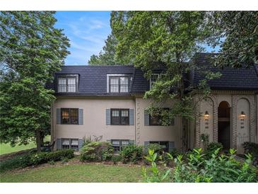 Charming two-story home with lush landscaping, shuttered windows, and an arched entrance at 170 Elysian Nw Way, Atlanta, GA 30327