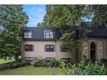 Charming townhome with a manicured lawn and mature trees provides natural shade and curb appeal at 170 Elysian Nw Way, Atlanta, GA 30327