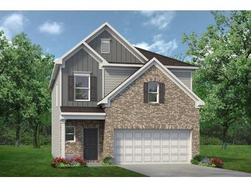 Charming two-story home featuring a brick facade, attached two-car garage, and a well-manicured front lawn at 1215 Elowen Dr, Austell, GA 30168