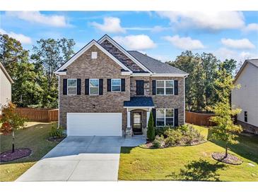 Charming two-story home with a brick facade, well-maintained landscaping, and a two-car garage at 529 Azalea Bloom Dr, Loganville, GA 30052