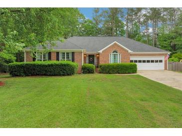 Charming brick home with a lush green lawn and manicured hedges at 1050 Chestnut Hill Sw Cir, Marietta, GA 30064