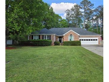 Charming brick ranch-style home with a well-maintained lawn and an attached two-car garage at 1050 Chestnut Hill Sw Cir, Marietta, GA 30064
