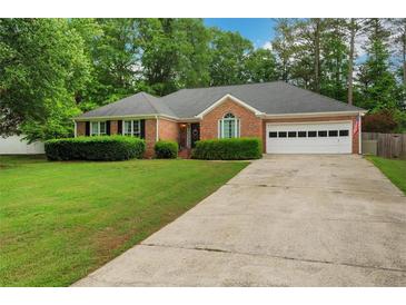 Charming brick home with manicured lawn and a two-car garage, perfect for suburban living at 1050 Chestnut Hill Sw Cir, Marietta, GA 30064