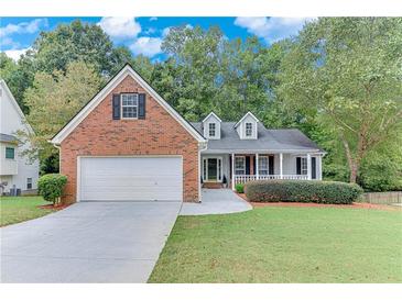 Charming one-story home featuring brick accents, a two-car garage, and a well-manicured lawn in a quiet neighborhood at 3238 Sharp Creek Ln, Buford, GA 30519