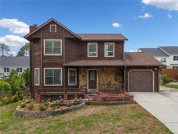 Charming two-story home with stone accents, attached garage, and a landscaped front yard at 893 Sandune Dr, Norcross, GA 30093