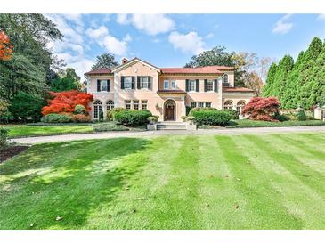 Elegant home featuring a sprawling lawn, manicured landscaping, and a classic Mediterranean-style facade at 15 Cherokee Nw Rd, Atlanta, GA 30305