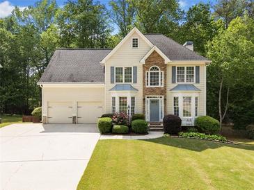 Charming two-story traditional home with manicured lawn, blue shutters, and a two-car garage at 1126 Gate Post Ct, Powder Springs, GA 30127