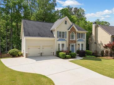 Inviting two-story home with a manicured lawn, stone accents, and a two-car garage at 1126 Gate Post Ct, Powder Springs, GA 30127