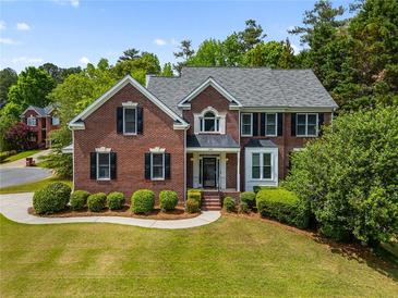 Beautiful two-story brick home with a manicured lawn, lush greenery, and charming curb appeal at 1552 Brentwood Dr, Marietta, GA 30062