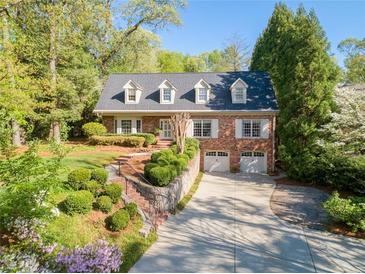 Charming brick home featuring a manicured lawn, beautiful landscaping and a private two-car garage at 4584 E Conway Nw Dr, Atlanta, GA 30327