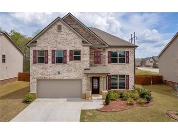 Charming two-story home with brick facade, well-manicured lawn, and attached two-car garage at 509 Azalea Bloom Dr, Loganville, GA 30052