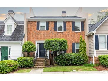 Charming brick townhouse featuring black shutters, well-manicured landscaping, and welcoming front entrance at 911 Lenox Hill Ne Ct, Atlanta, GA 30324