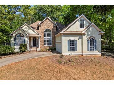 Charming home featuring stone accents, lush landscaping, and a welcoming front entrance at 115 Stonewall Dr, Covington, GA 30016