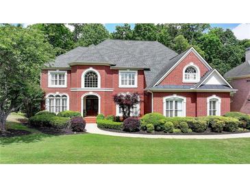Stately red brick home with manicured landscaping and lush greenery, creating curb appeal at 1875 Briergate Dr, Duluth, GA 30097