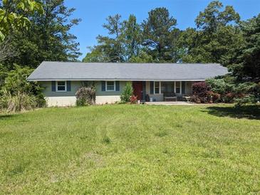 Charming single-story home with a well-maintained yard and a serene, tree-lined backdrop at 2291 Piney Grove Rd, Loganville, GA 30052