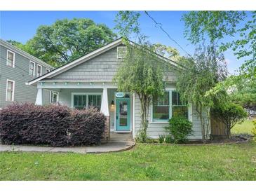 Charming home featuring fresh landscaping and a welcoming front porch with light blue door and trim at 1283 Mercer Ave, East Point, GA 30344
