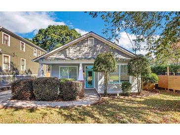 Charming bungalow-style home featuring a front yard, grey siding, and a bright blue front door at 1283 Mercer Ave, East Point, GA 30344
