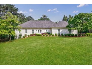 Charming one story home with manicured lawn, lush landscaping, and painted brick exterior at 1550 Masters Club Dr, Sandy Springs, GA 30350