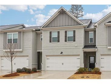 Charming townhome featuring a two-car garage, neutral brick, and well-maintained landscaping at 5575 Rock Place Ct, Norcross, GA 30093