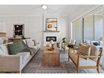 Comfortable living room with modern decor, fireplace, and sliding glass doors to the outside patio at 677 Stickley Oak Way, Woodstock, GA 30189