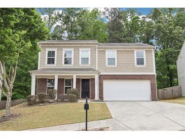 Charming two-story home with a brick facade, a well-manicured lawn, and inviting curb appeal at 1647 Shire Village Dr, Sugar Hill, GA 30518