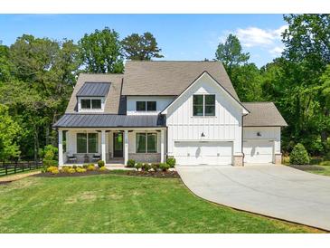 Charming two-story modern farmhouse with a manicured lawn, a welcoming front porch, and a three-car garage at 3610 Burnt Bridge Rd, Cumming, GA 30028