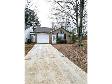 Charming brick home featuring an attached garage and a well-maintained front yard at 3647 Diamond Cir, Decatur, GA 30034