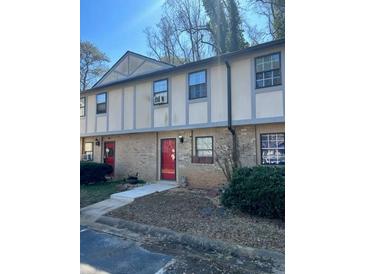 Charming townhouse features a brick facade, red door, and well-maintained landscaping at 1151 Rankin St # 2B, Stone Mountain, GA 30083