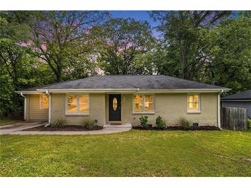 Charming brick ranch home with a manicured lawn and lush greenery creating inviting curb appeal at 2308 Scotty Cir, Decatur, GA 30032