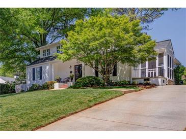 Charming white home featuring a lush green lawn and a mature shade tree at 26 Kensington Rd, Avondale Estates, GA 30002
