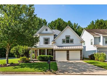 Charming two-story home featuring a two-car garage, inviting front porch, and lush landscaping at 301 Downing Creek Trl, Canton, GA 30114