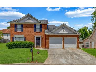 Charming two-story brick home with a well-manicured lawn and attached two car garage at 4000 Crossings Way, Stone Mountain, GA 30083