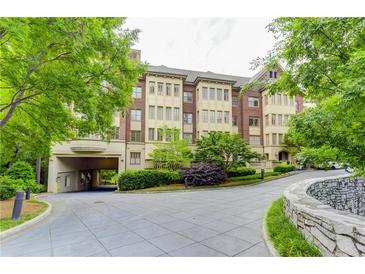 Elegant condo building with lush landscaping, a circular drive and covered parking area at 1717 N Decatur Ne Rd # 214, Atlanta, GA 30307