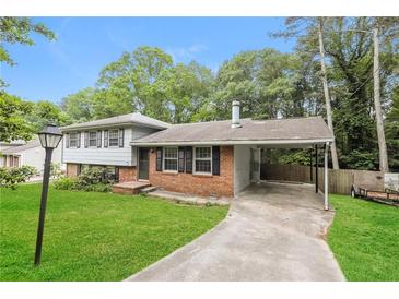 Charming split-level home featuring a carport, brick accents, and a well-manicured lawn at 2757 Shelley Ln, Ellenwood, GA 30294