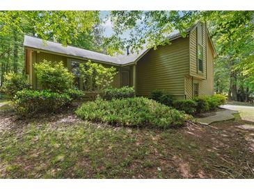 Inviting home featuring lush landscaping, natural light, and a peaceful, tree-lined setting at 3335 New Heritage Dr, Alpharetta, GA 30022